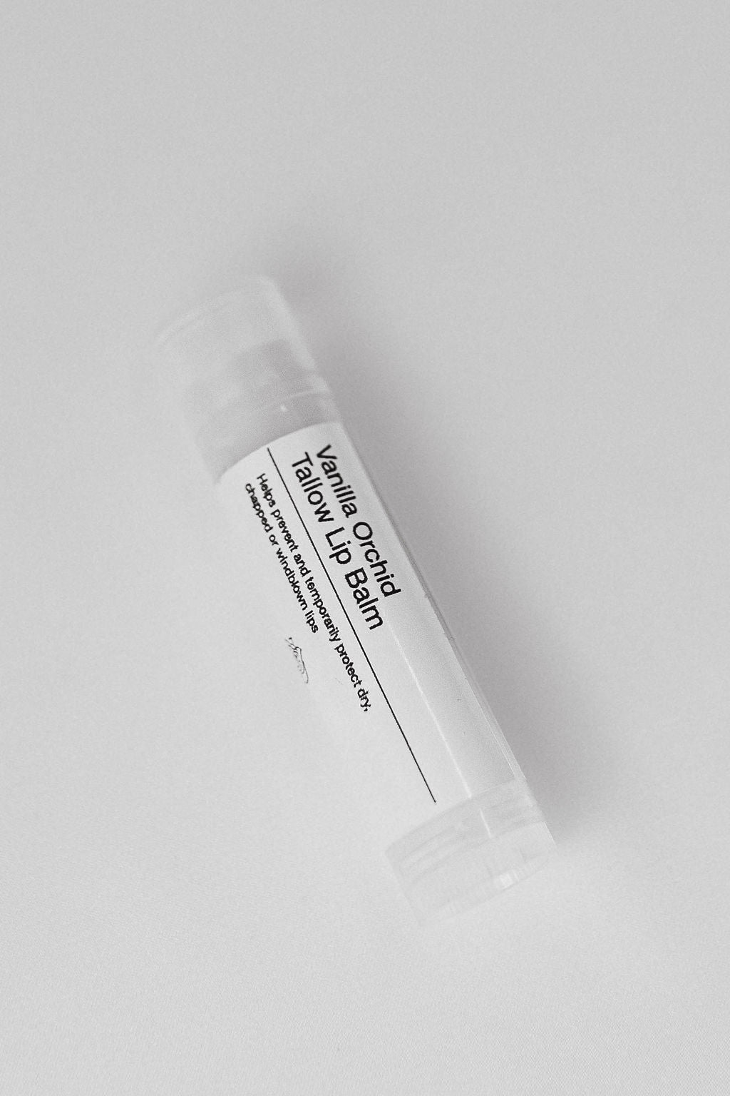 Vanilla Orchid tallow lip balm tube on a light gray background