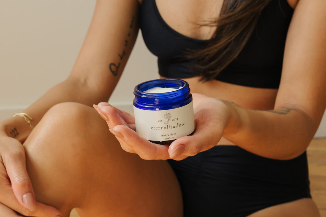 Person holding a jar of 'eternal tallow' cream