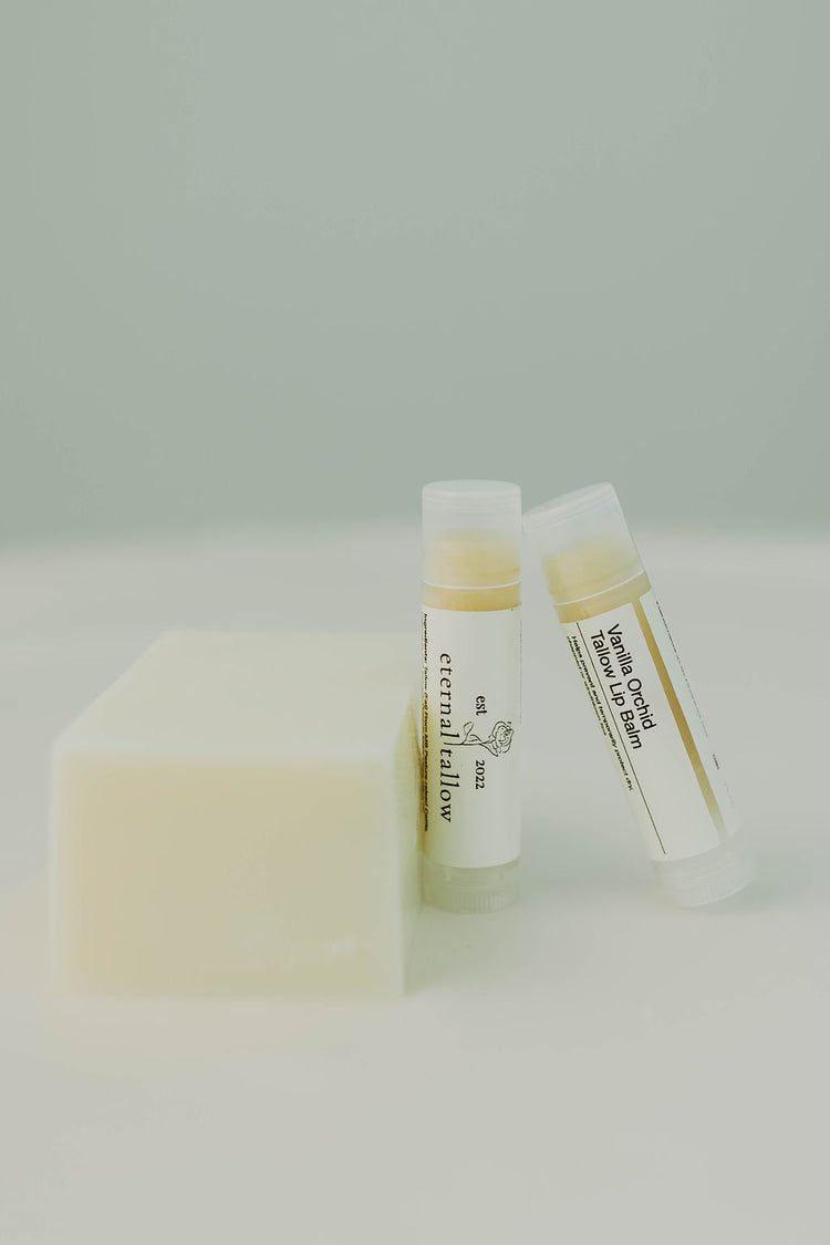 Bar of soap and two tubes of organic tallow lip balm on a white background