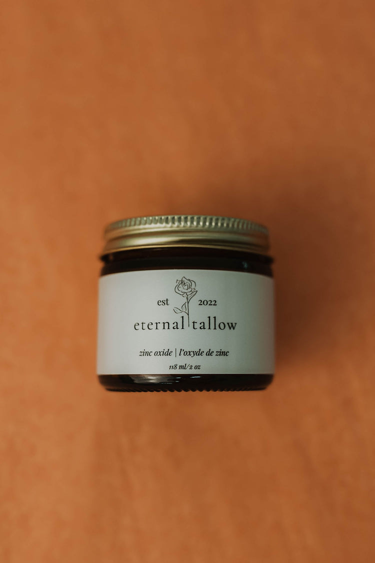 Jar of 'eternal tallow' zinc oxide lotion on a brown background